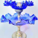 LOTE 180 - LINDA DOCEIRA FRANCESA EM METAL ESPESSURADO A PRATA E VIDRO MÃO AZUL COBALTO. 32 CM DE ALTURA (NO ESTADO)
