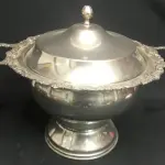 LOTE 289 - GRANDE SOPEIRA ESPESSURADO A PRATA, COM 24 CM ALT. (NO ESTADO)