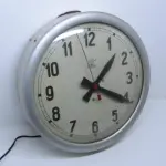 LOTE 476 - RELÓGIO DE PAREDE TAGUS SINCRO - ELÉTRICO, FUNCIONANDO CAIXA EM METAL BEM CONSERVADA VIDRO BOMBE, MEDE 36CM DE DIÂMETRO X 7,5CM DE PROFUNDIDADE.(NO ESTADO)