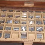 LOTE 477 - MÁQUINA DE PERSONALIZAR GUARDANAPOS CANETAS ETC COMPLETÍSSIMA COM  JOGOS DE LETRAS MANUSCRITAS,  MAIÚSCULAS, MINÚSCULAS, NÚMEROS, ROLOS DE FITAS PARA PERSONALIZAR (NO ESTADO)