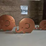 LOTE 375 - 01 TRIO ELEFANTINHOS EM MADEIRA NA COR COBRE (NOVO) (NO ESTADO)