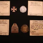 LOTE 036 - LOTE 36 – MEDALHAS ALEMANHA 	MEDALHA	OBSERVAÇÕES 1.		Cruz de Ferro Alemã. 1914 Gravador: José Peón	Reverso liso - envelope da Coleção Júlio Estrella Moreira 2.		Beneficente da Cruz Vermelha Austro-Alemã. 1915	Prateada - envelope da Coleção Júlio Estrella Moreira 3.		Deustche Woche (Semana Alemã). 1937. Curitiba Gravador: Eduardo Muller	Reverso liso - envelope da Coleção Júlio Estrella Moreira 4.		Águia Alemã com pergaminho Gravador: Henrique Kaminski – A Pérola	Reverso liso - envelope da Coleção Júlio Estrella Moreira