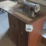 LOTE 599 - 01 MÁQUINA DE COSTURA ANTIGA MARCA SINGER.  (NO ESTADO) ATENÇÃO! FAZER A VISITAÇÃO ANTES DE ARREMATAR, NÃO SABEMOS SE FUNCIONA, LEILÃO NÃO TEM GARANTIA E NEM DEVOLUÇÃO, SUJEITO A POSSÍVEIS AVARIAS VISÍVEIS/OCULTAS E/OU AUSÊNCIA DE COMPONENTES.