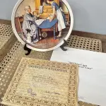 01 RARO PRATO DE "1983 ADD TWO CUPS AND A MEASURE OF LOVE - COLLECTIBLE PORCELAIN PLATE", DE NORMAN ROCKWELL! FABRICADO PELA KNOWLES, A MARCA MAIS ANTIGA DA AMÉRICA EM PORCELANA FINA. MEDE APROXIMADAMENTE 21,5 CM DE DIÂMETRO.NO VERSO DO PRATO ESTÁ ESCRITO: "DA PRIMEIRA EDIÇÃO LIMITADA, 'ADD TWO CUPS AND A MEASURE OF LOVE', DE NORMAN ROCKWELL. O OITAVO DE UMA SÉRIE ANUAL PARA O DIA DAS MÃES. COM CERTIFICADO DE ALTENCIDADE PELA ROCKWELL SOCIETY OF AMERICA. FEITO EM EDIÇÃO LIMITADA, PERMANENTEMENTE FECHADO EM 8 DE MAIO DE 1983, POR KNOWLES.ITEM COMPRADO EM GAREGEM DE ANTIGUIDADES NOS EUA.SUPORTE PARA PRATO NÃO INCLUÍDO NESTA VENDA. (NO ESTADO) ATENÇÃO! FAZER A VISITAÇÃO ANTES DE ARREMATAR, NÃO SABEMOS SE FUNCIONA, LEILÃO NÃO TEM GARANTIA E NEM DEVOLUÇÃO, SUJEITO A POSSÍVEIS AVARIAS VISÍVEIS/OCULTAS E/OU AUSÊNCIA DE COMPONENTES.