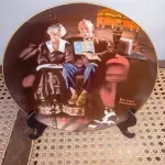 01 BELO PRATO NORMAN ROCKWELL COM 21,5 CM DE DIÂMETRO APRESENTA A ICÔNICA OBRA DE ARTE DE NORMAN ROCKWELL INTITULADA "EVENING'S EASE". FABRICADO NOS ESTADOS UNIDOS DURANTE A DÉCADA DE 1980, ESTE PRATO MULTICOLORIDO RETRATA A CENA SERENA DE UMA MULHER DESFRUTANDO DE UM MOMENTO DE PAZ EM SUA VARANDA. UMA ÓTIMA ADIÇÃO A QUALQUER COLEÇÃO DE ITENS DECORATIVOS COLECIONÁVEIS. FEITO EM UMA EDIÇÃO ESTRITAMENTE LIMITADA A 50 DIAS DE QUEIMA NOS EUA. POR KNOWLES, O NOME MAIS ANTIGO DA AMÉRICA EM FINE PORCELANA CHINA. ITEM DE COLECIONADOR, CAIXA ORIGINAL E COM CERTIFICADO DE AUTENTICIDADE. SUPORTE PARA PRATO NÃO INCLUÍDO NESTA VENDA. (NO ESTADO) ATENÇÃO! FAZER A VISITAÇÃO ANTES DE ARREMATAR, NÃO SABEMOS SE FUNCIONA, LEILÃO NÃO TEM GARANTIA E NEM DEVOLUÇÃO, SUJEITO A POSSÍVEIS AVARIAS VISÍVEIS/OCULTAS E/OU AUSÊNCIA DE COMPONENTES.