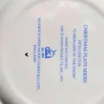 01 LINDO PRATO DE NATAL DA SÉRIE AVON CHRISTMAS PLATE DE 1977, "CAROLLERS IN THE SNOW" - QUINTA EDIÇÃO DA SÉRIE. COM 22 CM DE DIÂMETRO E RETRATA UM GRUPO DE CANTORES DE NATAL EM FRENTE A UMA CASA DE DOIS ANDARES NO CENTRO. O VERSO MARCADO: SÉRIE DE PRATOS DE NATAL QUINTA EDIÇÃO "CANTORES DE NATAL NA NEVE" COM DOIS ANÉIS DE OURO 22K E O NATAL DE 1979 TAMBÉM EM OURO 22K.  FEITO EXCLUSIVAMENTE PARA A AVON CTS INC., 1977 POR ENOCH WEDGWOOD (TUNSTALL) LTD., INGLATERRA PEÇA COMPRADA EM GARAGEM DE ANTIGUIDADES NOS EUA. SUPORTE PARA PRATO NÃO INCLUÍDO NESTA VENDA. (NO ESTADO) ATENÇÃO! FAZER A VISITAÇÃO ANTES DE ARREMATAR, NÃO SABEMOS SE FUNCIONA, LEILÃO NÃO TEM GARANTIA E NEM DEVOLUÇÃO, SUJEITO A POSSÍVEIS AVARIAS VISÍVEIS/OCULTAS E/OU AUSÊNCIA DE COMPONENTES.