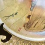 01 BELO PRATO NORMAN ROCKWELL COM 20 CM DE DIÂMETRO APRESENTA A ICÔNICA OBRA DE ARTE DE NORMAN ROCKWELL HUCK FINN SÉRIE 4 "A FUGA DA SERPENTE "NORMAN ROCKWELL DAVE GROSSMAN DESIGN INC. PORCELANA FINA FABRICADO NO JAPÃO NA DÉCADA DE 80 QUARTO DE UMA SÉRIE DE 4EDIÇÃO LIMITADA DE 1981, COM LANÇAMENTO NA ÉPOCA DE APENAS 10.000 EXEMPLARES, PEÇA COMPRADA EM GARAGEM DE ANTIGUIDADES NOS EUA. SUPORTE PARA PRATO NÃO INCLUÍDO NESTA VENDA. (NO ESTADO) ATENÇÃO! FAZER A VISITAÇÃO ANTES DE ARREMATAR, NÃO SABEMOS SE FUNCIONA, LEILÃO NÃO TEM GARANTIA E NEM DEVOLUÇÃO, SUJEITO A POSSÍVEIS AVARIAS VISÍVEIS/OCULTAS E/OU AUSÊNCIA DE COMPONENTES.