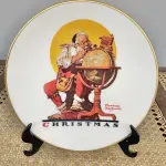 01 BELO PRATO DE COLECIONADOR DE NORMAN ROCKWELL APRESENTA A EMOCIONANTE CENA DE "PLANEJANDO VISITAS DE NATAL" E É UM ITEM ESSENCIAL PARA QUALQUER COLEÇÃO. TEM BORDAS A OURO 24 K  COM 21,5 CM DE DIÂMETRO E É REPLETO DE DETALHES INTRINCADOS E CORES VIBRANTES QUE DÃO VIDA À CENA. O PRATO FOI FABRICADO NA DÉCADA DE 1970 PELA GORHAM, NOS ESTADOS UNIDOS. É UM ITEM VINTAGE E ESTÁ EM ÓTIMO ESTADO, PRONTO PARA SER EXIBIDO E APRECIADO POR MUITOS ANOS. ESTE SERIA UM PRESENTE PERFEITO PARA QUALQUER COLECIONADOR OU AMANTE DA OBRA DE NORMAN ROCKWELL.ITEM COMPRADO EM GARAGENS DE ANTIGUIDADES NOS EUA. SUPORTE PARA PRATO NÃO INCLUÍDO NESTA VENDA. (NO ESTADO) ATENÇÃO! FAZER A VISITAÇÃO ANTES DE ARREMATAR, NÃO SABEMOS SE FUNCIONA, LEILÃO NÃO TEM GARANTIA E NEM DEVOLUÇÃO, SUJEITO A POSSÍVEIS AVARIAS VISÍVEIS/OCULTAS E/OU AUSÊNCIA DE COMPONENTES.