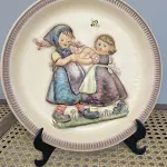 01 RARO E DIFERENCIADO  PRATO DE EDIÇÃO DE  ANIVERSÁRIO DE GOEBEL M.J. HUMMEL, 1980, "SPRING DANCE", 25 CM - PERFEITO, NA CAIXA ORIGINAL. E COM SEUS FOLHETOS ORIGINAIS ESTE FOI FABRICADO NA ALEMANHA OCIDENTAL. O PRATO TEM 25 CM DE DIÂMETRO E ESTÁ EM PERFEITAS CONDIÇÕES. GUARDADOS HÁ ANOS. ITEM COMPRADO E GARAGENS DE ANTIGUIDADES NOS EUA. SUPORTE PARA PRATO NÃO INCLUÍDO NESTA VENDA. (NO ESTADO) ATENÇÃO! FAZER A VISITAÇÃO ANTES DE ARREMATAR, NÃO SABEMOS SE FUNCIONA, LEILÃO NÃO TEM GARANTIA E NEM DEVOLUÇÃO, SUJEITO A POSSÍVEIS AVARIAS VISÍVEIS/OCULTAS E/OU AUSÊNCIA DE COMPONENTES.