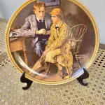 01 RARO PRATO DE NORMAN ROCKWELL "CONFIANDO NA TOCA" PEÇA DE COLECIONADOR VINTAGE NORMAN ROCKWELL " EM INGLÊS "CONFIDING IN THE DEN" COM DETALHES EM OURO 24K. PRATO NUMERADO DE PORCELANA FINA EDWIN M. KNOWLES. EDIÇÃO LIMITADA DE NORMAN ROCKWELL, DÉCIMA PRIMEIRA EDIÇÃO DA COLEÇÃO MULHERES REDESCOBERTAS DE ROCKWELL, FEITA EM UMA EDIÇÃO ESTRITAMENTE LIMITADA A CEM DIAS DE QUEIMA E CERTIFICADA COMO UM "VERDADEIRO CLÁSSICO ROCKWELL" PELA ROCKWELL SOCIETY OF AMERICA. COM CERTIFICADO DE AUTENTICIDADE E CAIXA ORIGINAL. O PRATO MEDE 21,5 CM DE DIÂMETRO. SUPORTE PARA PRATO NÃO INCLUÍDO NESTA VENDA. (NO ESTADO) ATENÇÃO! FAZER A VISITAÇÃO ANTES DE ARREMATAR, NÃO SABEMOS SE FUNCIONA, LEILÃO NÃO TEM GARANTIA E NEM DEVOLUÇÃO, SUJEITO A POSSÍVEIS AVARIAS VISÍVEIS/OCULTAS E/OU AUSÊNCIA DE COMPONENTES.