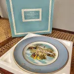 01 LINDO PRATO DE NATAL DA SÉRIE AVON CHRISTMAS PLATE DE 1977, "CAROLLERS IN THE SNOW" - QUINTA EDIÇÃO DA SÉRIE. COM 22 CM DE DIÂMETRO E RETRATA UM GRUPO DE CANTORES DE NATAL EM FRENTE A UMA CASA DE DOIS ANDARES NO CENTRO. O VERSO MARCADO: SÉRIE DE PRATOS DE NATAL QUINTA EDIÇÃO "CANTORES DE NATAL NA NEVE" COM DOIS ANÉIS DE OURO 22K E O NATAL DE 1979 TAMBÉM EM OURO 22K.  FEITO EXCLUSIVAMENTE PARA A AVON CTS INC., 1977 POR ENOCH WEDGWOOD (TUNSTALL) LTD., INGLATERRA PEÇA COMPRADA EM GARAGEM DE ANTIGUIDADES NOS EUA. SUPORTE PARA PRATO NÃO INCLUÍDO NESTA VENDA. (NO ESTADO) ATENÇÃO! FAZER A VISITAÇÃO ANTES DE ARREMATAR, NÃO SABEMOS SE FUNCIONA, LEILÃO NÃO TEM GARANTIA E NEM DEVOLUÇÃO, SUJEITO A POSSÍVEIS AVARIAS VISÍVEIS/OCULTAS E/OU AUSÊNCIA DE COMPONENTES.