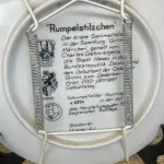 01 BELO PRATO DE COLECIONADOR DO FAMOS ARTISTA CHARLES GEHM, COM 20 CM DE DIÂMETRO RETRATA UM CONTO DE FADAS CLÁSSICO DOS IRMÃOS GRIMM, RUPELSTILZCHEN. PRODUZIDA PELA KÖNIGSZELT BAVARIA EM UMA EDIÇÃO LIMITADA EM 1981.COM O CERTIFICADO DE AUTENTICIDADE  E FOLHETOS DOS MESMO  FABRICADO NA ALEMANHA EM 1981, O PRATO APRESENTA UM ESTILO E TÉCNICA DE PRODUÇÃO EM CERÂMICA ARTÍSTICA REQUINTADA. O PRATO ESTÁ EM PERFEITAS CONDIÇÕES, PRONTO PARA SER EXIBIDO OU ADICIONADO À COLEÇÃO DE PRATOS DE QUALQUER COLECIONADOR. A ÉPOCA DO PRATO SITUA-SE NO FINAL DO SÉCULO XX, ESPECIFICAMENTE ENTRE OS ANOS DE 1970 E 1999.ITEM COMPRADO E GARAGENS DE ANTIGUIDADES NOS EUA. SUPORTE PARA PRATO NÃO INCLUÍDO NESTA VENDA. (NO ESTADO) ATENÇÃO! FAZER A VISITAÇÃO ANTES DE ARREMATAR, NÃO SABEMOS SE FUNCIONA, LEILÃO NÃO TEM GARANTIA E NEM DEVOLUÇÃO, SUJEITO A POSSÍVEIS AVARIAS VISÍVEIS/OCULTAS E/OU AUSÊNCIA DE COMPONENTES.