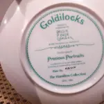 01 PRATO DE COLECIONADOR SUNBEAM BESSIE PEASE GUTMAN CAMEO PORTRAIT ASSINADO E NUMERADO, ESTE PRATO VINTAGE DE COLECIONADOR GOLDILOCKS DE 1986, DA COLEÇÃO HAMILTON, É UM ITEM ESSENCIAL PARA QUALQUER COLECIONADOR DE CULTURA AMERICANA. É A 4ª EDIÇÃO DA PRECIOUS PORTRAITS E TEM O NÚMERO AUTÊNTICO 4317P.FEITO DE PORCELANA DE ALTA QUALIDADE, ESTE PRATO APRESENTA UMA BELA E VIBRANTE IMAGEM MULTICOLORIDA DE UMA JOVEM QUE ADICIONARÁ UM TOQUE DE ELEGÂNCIA A QUALQUER COLEÇÃO DECORATIVA.EM EXCELENTE ESTADO, POSSUI A CAIXA ORIGINAL E OS DOCUMENTOS. O SUPORTE DO PRATO NÃO ESTÁ INCLUÍDO. PEÇA COMPRADA EM GARAGEM DE ANTIGUIDADES NOS EUA. SUPORTE PARA PRATO NÃO INCLUÍDO NESTA VENDA. (NO ESTADO) ATENÇÃO! FAZER A VISITAÇÃO ANTES DE ARREMATAR, NÃO SABEMOS SE FUNCIONA, LEILÃO NÃO TEM GARANTIA E NEM DEVOLUÇÃO, SUJEITO A POSSÍVEIS AVARIAS VISÍVEIS/OCULTAS E/OU AUSÊNCIA DE COMPONENTES.