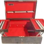 01 ANTIGA CAIXA FAQUEIROS ARTE DÉCOR. ANOS 50, EM MADEIRA NOBRE, INTERIOR COM FORRAÇÃO EM TECIDO AVELUDADO. ACOMPANHA CHAVE. COM 18X55X42 CM. SEM CUPIM PRECISA APENAS DE UMA LIMPEZA, POIS FOI EMBALADA COM FITA MARCAS DAS FOTOS SAI FÁCIL