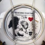 01 PRATO DE COLECIONADOR VINTAGE REACHING TOGETHER POR SUE ETEM 1982 EDIÇÃO LIMITADA APENAS 40 MIL LANÇADOS NOS EUA. PRATO DE NUMERO 3487 RARA POUCAS DELAS EM ANTIQUÁRIOS NOS EUA. ASSINADO PELO ARTISTA 1982, PRATO AMERICAN LEGACY REACHING TOGETHER SU ETE. ESTE BELO PRATO DE COLECIONADOR UM ITEM ESSENCIAL PARA QUALQUER COLECIONADOR SÉRIO. COM UM DESIGN MULTICOLORIDO E TEMA DE PESSOAS, ESTE PRATO É PERFEITO PARA TODAS AS OCASIÕES. FEITO DE PORCELANA DE OSSO, COM 21 CM DE DIÂMETRO. É UM ITEM VINTAGE DO FINAL DO SÉCULO XX E ASSINADO PELA ARTISTA SU ETEM, COM O NÚMERO DE PRODUÇÃO 27390. FAZ PARTE DA LINHA DE PRODUTOS AMERICAN LEGACY E FOI PRODUZIDO NA CALIFÓRNIA NA DÉCADA DE 1980. PERFEITO PARA QUALQUER DECORAÇÃO. O PRATO É UM EXEMPLO DO ESTILO E DA TÉCNICA DE PRODUÇÃO EM CERÂMICA ARTÍSTICA. ESTE ITEM É UMA ÓTIMA REPRESENTAÇÃO DA CULTURA E HISTÓRIA AMERICANAS. PEÇA FOI ENCONTRADA EM UM ARMÁRIO DURANTE A VENDA DE UMA PROPRIEDADE, APÓS MUITOS ANOS GUARDADA.  CAIXA ORIGINAL E CERTIFICADO DE AUTENTICIDADE DA PEÇA.  SUPORTE PARA PRATO NÃO INCLUÍDO NESTA VENDA. (NO ESTADO) ATENÇÃO! FAZER A VISITAÇÃO ANTES DE ARREMATAR, NÃO SABEMOS SE FUNCIONA, LEILÃO NÃO TEM GARANTIA E NEM DEVOLUÇÃO, SUJEITO A POSSÍVEIS AVARIAS VISÍVEIS/OCULTAS E/OU AUSÊNCIA DE COMPONENTES.