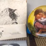 01 LINDO PRATO DE COLECIONADOR DE SUE ETEM "LOVE IN YOUR HEART", ASSINADO À MÃO O PRATO TEM 21 CM É O Nº 5421 DE UMA EDIÇÃO LIMITADA DE 40.000 EXEMPLARES NO TOTAL DA AMERICAN LEGACY LTD. 1984 E RETRATA DUAS CRIANÇAS SE ABRAÇANDO. SUE ETEM É CONHECIDA POR SUAS BELAS REPRESENTAÇÕES DE CRIANÇAS EM CORES VIBRANTES E DIMENSÕES, E O PRATO É ASSINADO POR ELA NO VERSO, EM SUA CAIXA ORIGINAL. PEÇA COMPRADA EM GARAGEM DE ANTIGUIDADES NOS EUA. SUPORTE PARA PRATO NÃO INCLUÍDO NESTA VENDA. (NO ESTADO) ATENÇÃO! FAZER A VISITAÇÃO ANTES DE ARREMATAR, NÃO SABEMOS SE FUNCIONA, LEILÃO NÃO TEM GARANTIA E NEM DEVOLUÇÃO, SUJEITO A POSSÍVEIS AVARIAS VISÍVEIS/OCULTAS E/OU AUSÊNCIA DE COMPONENTES.