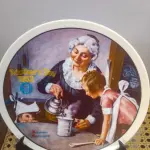 01 PRATO DE NORMAN ROCKWELL PARA O DIA DAS MÃES DE 1982, "THE COOKING LESSON", DA PORCELANA FINA KNOWLES. O NÚMERO DO PRATO É 13025N , DA PRIMEIRA EDIÇÃO LIMITADA. O SÉTIMO DE UMA SÉRIE ANUAL PARA O DIA DAS MÃES. CERTIFICADO PELA ROCKWELL SOCIETY OF AMERICA. ESTE PRATO É UMA EDIÇÃO LIMITADA, PERMANENTEMENTE FECHADA, FEITA EM 7 DE MAIO DE 1982 PELA KNOWLES, A MARCA MAIS ANTIGA DA AMÉRICA EM PORCELANA FINA. O PRATO MEDE 21,8 CM DE DIÂMETRO E ESTÁ EM ÓTIMO ESTADO ITEM COMPRADO EM 2/10/1982 COM CERTIFICADO DE AUTENTICIDADE NOTAS E DOCUMENTOS DE COMPRA.  ITEM COMPRADO EM GARAGENS DE ANTIGUIDADES NOS EUA.SUPORTE PARA PRATO NÃO INCLUÍDO NESTA VENDA. (NO ESTADO) ATENÇÃO! FAZER A VISITAÇÃO ANTES DE ARREMATAR, NÃO SABEMOS SE FUNCIONA, LEILÃO NÃO TEM GARANTIA E NEM DEVOLUÇÃO, SUJEITO A POSSÍVEIS AVARIAS VISÍVEIS/OCULTAS E/OU AUSÊNCIA DE COMPONENTES.