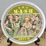 01 LINDO PRATO DE COLECIONADOR MASH 4077ª EDIÇÃO ÚLTIMA TEMPORADA DA SÉRIE DE TELEVISÃO MASH, LIMITADA NA CAIXA ORIGINAL. COM  21,5 CM DE DIÂMETRO, FABRICADO EM 1982 PELA ROYAL ORLEANS PARA A TWENTIETH CENTURY-FOX. UM PRATO MUITO BONITO. NO VERSO, HÁ UMA LISTA COM O NOME DOS ATORES. DISTRIBUÍDO EXCLUSIVAMENTE PELA ROYAL ORLEANS, NOVA ORLEANS, LA. COM CERTIFICADO DE AUTENTICIDADE E DOCUMENTOS. ITEM COMPRADO E GARAGENS DE ANTIGUIDADES NOS EUA. SUPORTE PARA PRATO NÃO INCLUÍDO NESTA VENDA. (NO ESTADO) ATENÇÃO! FAZER A VISITAÇÃO ANTES DE ARREMATAR, NÃO SABEMOS SE FUNCIONA, LEILÃO NÃO TEM GARANTIA E NEM DEVOLUÇÃO, SUJEITO A POSSÍVEIS AVARIAS VISÍVEIS/OCULTAS E/OU AUSÊNCIA DE COMPONENTES.