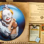 01 PRATO DE EDWARD J. ROHN CASA DA MOEDA DE CARSON "WHITE-FALDED CLOWN" DA CARSON MINT. PRIMEIRO PRATO DA SÉRIE "BIG TOP", EM PORTUGUES "A ROSTO BRANCO".1981, COM DIÂMETRO DE 21,5 CM, PERFEITO, COM CAIXA ORIGINAL E CERTIFICADO DE AUTENTICIDADE VENDAS DESSE PRATO DOI DE APENAS 60 DIAS NOS EUA E LOGO EM SEGUIDA FECHADA AS VENAS ITEM RARO.PEÇA COMPRADA EM GARAGEM DE ANTIGUIDADES NOS EUA. “SUPORTE PARA PRATO NÃO INCLUÍDO NESTA VENDA.” . (NO ESTADO) ATENÇÃO! FAZER A VISITAÇÃO ANTES DE ARREMATAR, NÃO SABEMOS SE FUNCIONA, LEILÃO NÃO TEM GARANTIA E NEM DEVOLUÇÃO, SUJEITO A POSSÍVEIS AVARIAS VISÍVEIS/OCULTAS E/OU AUSÊNCIA DE COMPONENTES.