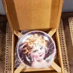 01 RARO PRATO DE PORCELANA SUNBEAM DE COLECIONADOR DE 1986, COM BELO CAMAFEU DE BESSIE PEASE GUTMAN, RETRATO PRECIOSO, ASSINADO E NUMERADO. MEDE APROXIMADAMENTE 21 CM DE DIÂMETRO. O PRATO DA COLEÇÃO HAMILTON, NÚMERO 2115R. ESTE PRATO DE COLECIONADOR VINTAGE SUNBEAM DE 1986 DA COLEÇÃO HAMAMTON É UM ITEM ESSENCIAL PARA QUALQUER COLECIONADOR DE CULTURA AMERICANA. É A PRIMEIRA EDIÇÃO DOS PRECIOUS PORTRAITS E É AUTENTICAMENTE NUMERADA 2115R. ESTE PRATO É FEITO DE PORCELANA DE ALTA QUALIDADE E APRESENTA UMA BELA E VIBRANTE IMAGEM MULTICOLORIDA DE UMA JOVEM, ADICIONANDO UM TOQUE DE ELEGÂNCIA A QUALQUER COLEÇÃO DECORATIVA.POSSUI A CAIXA ORIGINAL CERTIFICADO DE AUTENTICIDADE E OS DOCUMENTOS.O SUPORTE DO PRATO NÃO ESTÁ INCLUÍDO. PEÇA COMPRADA EM GARAGEM DE ANTIGUIDADES NOS EUA. SUPORTE PARA PRATO NÃO INCLUÍDO NESTA VENDA. (NO ESTADO) ATENÇÃO! FAZER A VISITAÇÃO ANTES DE ARREMATAR, NÃO SABEMOS SE FUNCIONA, LEILÃO NÃO TEM GARANTIA E NEM DEVOLUÇÃO, SUJEITO A POSSÍVEIS AVARIAS VISÍVEIS/OCULTAS E/OU AUSÊNCIA DE COMPONENTES.