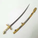 01 MINIATURA DE ESPADA DA MARINHA EM METAL. LÂMINA CINZELADA DE  DUQUE DE CAIXAS  RJ. DA DECADA DE 80 BAINHA DE METAL COM APLIQUES EM METAL DOURADO,COM 15 CM DE CUMPRIMENTO. (NO ESTADO) ATENÇÃO! FAZER A VISITAÇÃO ANTES DE ARREMATAR, NÃO SABEMOS SE FUNCIONA, LEILÃO NÃO TEM GARANTIA E NEM DEVOLUÇÃO, SUJEITO A POSSÍVEIS AVARIAS VISÍVEIS/OCULTAS E/OU AUSÊNCIA DE COMPONENTES.