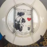 01 LINDO PRATO DE COLECIONADOR DE SUE ETEM "LOVE IN YOUR HEART", ASSINADO À MÃO O PRATO TEM 21 CM É O Nº 5421 DE UMA EDIÇÃO LIMITADA DE 40.000 EXEMPLARES NO TOTAL DA AMERICAN LEGACY LTD. 1984 E RETRATA DUAS CRIANÇAS SE ABRAÇANDO. SUE ETEM É CONHECIDA POR SUAS BELAS REPRESENTAÇÕES DE CRIANÇAS EM CORES VIBRANTES E DIMENSÕES, E O PRATO É ASSINADO POR ELA NO VERSO, EM SUA CAIXA ORIGINAL. PEÇA COMPRADA EM GARAGEM DE ANTIGUIDADES NOS EUA. SUPORTE PARA PRATO NÃO INCLUÍDO NESTA VENDA. (NO ESTADO) ATENÇÃO! FAZER A VISITAÇÃO ANTES DE ARREMATAR, NÃO SABEMOS SE FUNCIONA, LEILÃO NÃO TEM GARANTIA E NEM DEVOLUÇÃO, SUJEITO A POSSÍVEIS AVARIAS VISÍVEIS/OCULTAS E/OU AUSÊNCIA DE COMPONENTES.