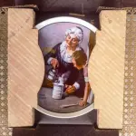 01 PRATO DE NORMAN ROCKWELL PARA O DIA DAS MÃES DE 1982, "THE COOKING LESSON", DA PORCELANA FINA KNOWLES. O NÚMERO DO PRATO É 13025N , DA PRIMEIRA EDIÇÃO LIMITADA. O SÉTIMO DE UMA SÉRIE ANUAL PARA O DIA DAS MÃES. CERTIFICADO PELA ROCKWELL SOCIETY OF AMERICA. ESTE PRATO É UMA EDIÇÃO LIMITADA, PERMANENTEMENTE FECHADA, FEITA EM 7 DE MAIO DE 1982 PELA KNOWLES, A MARCA MAIS ANTIGA DA AMÉRICA EM PORCELANA FINA. O PRATO MEDE 21,8 CM DE DIÂMETRO E ESTÁ EM ÓTIMO ESTADO ITEM COMPRADO EM 2/10/1982 COM CERTIFICADO DE AUTENTICIDADE NOTAS E DOCUMENTOS DE COMPRA.  ITEM COMPRADO EM GARAGENS DE ANTIGUIDADES NOS EUA.SUPORTE PARA PRATO NÃO INCLUÍDO NESTA VENDA. (NO ESTADO) ATENÇÃO! FAZER A VISITAÇÃO ANTES DE ARREMATAR, NÃO SABEMOS SE FUNCIONA, LEILÃO NÃO TEM GARANTIA E NEM DEVOLUÇÃO, SUJEITO A POSSÍVEIS AVARIAS VISÍVEIS/OCULTAS E/OU AUSÊNCIA DE COMPONENTES.