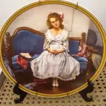 01 RARO  PRATO VINTAGE DE COLECIONADOR DA BRADFORD EXCHANGE APRESENTA A ICÔNICA PINTURA DE NORMAN ROCKWELL "ESPERANDO NO BAILE". ESTÁ COM CERTIFICADO DE AUTENTICIDADE NOTAS DE COMPRAS DA ÉPOCA DATADA EM 12/07/1982 O PRATO TEM 21 CM DE DIÂMETRO E É FEITO DE PORCELANA COM UM DESIGN MULTICOLORIDO. FAZ PARTE DA COLEÇÃO MULHERES REDESCOBERTAS DE ROCKWELL E É UMA EDIÇÃO LIMITADA E NUMERADA.O PRATO FOI PRODUZIDO NO FINAL DO SÉCULO XX UTILIZANDO O ESTILO E A TÉCNICA DE PRODUÇÃO DE CERÂMICA ARTÍSTICA. FOI FABRICADO NOS ESTADOS UNIDOS E É UM COMPLEMENTO PERFEITO PARA QUALQUER COLEÇÃO DE PRATOS DECORATIVOS DE COLECIONADOR. O PRATO ESTÁ EM EXCELENTE ESTADO E SERIA UM ÓTIMO PRESENTE PARA QUALQUER FÃ DE NORMAN ROCKWELL OU DE PRATOS DE COLECIONADOR. O SUPORTE DO PRATO NÃO ESTÁ INCLUÍDO. (NO ESTADO) ATENÇÃO! FAZER A VISITAÇÃO ANTES DE ARREMATAR, NÃO SABEMOS SE FUNCIONA, LEILÃO NÃO TEM GARANTIA E NEM DEVOLUÇÃO, SUJEITO A POSSÍVEIS AVARIAS VISÍVEIS/OCULTAS E/OU AUSÊNCIA DE COMPONENTES.