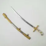 01 MINIATURA DE ESPADA DA MARINHA EM METAL. LÂMINA CINZELADA DE  DUQUE DE CAIXAS  RJ. DA DECADA DE 80 BAINHA DE METAL COM APLIQUES EM METAL DOURADO,COM 15 CM DE CUMPRIMENTO. (NO ESTADO) ATENÇÃO! FAZER A VISITAÇÃO ANTES DE ARREMATAR, NÃO SABEMOS SE FUNCIONA, LEILÃO NÃO TEM GARANTIA E NEM DEVOLUÇÃO, SUJEITO A POSSÍVEIS AVARIAS VISÍVEIS/OCULTAS E/OU AUSÊNCIA DE COMPONENTES.