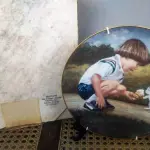 01 PRATO DE COLECIONADOR "MOMENTOS ESPECIAIS" "ENOUGH FOR TWO" DE LUCELLE RAAD, 1983. PRATO DE PORCELANA "ENOUGH FOR TWO". TERCEIRA EDIÇÃO DA SÉRIE "MOMENTOS ESPECIAIS". "ENOUGH FOR TWO" DE LUCELLE RAAD. EDIÇÃO LIMITADA A 12.500 UNIDADES EM TODO O MUNDO. NÚMERO DO PRATO: 512. COM 21 CM DE DIAMETRO . TERCEIRO DA SÉRIE "MOMENTOS ESPECIAIS". MENINO COMPARTILHANDO SUA CASQUINHA DE SORVETE COM UM GATINHO. EXCELENTE ESTADO DE USO. SEM LASCAS OU RACHADURAS. VEM NA CAIXA ORIGINAL, COM CERTIFICADO DE AUTENTICIDADE.SUPORTE PARA PRATO NÃO INCLUÍDO NESTA VENDA. (NO ESTADO) ATENÇÃO! FAZER A VISITAÇÃO ANTES DE ARREMATAR, NÃO SABEMOS SE FUNCIONA, LEILÃO NÃO TEM GARANTIA E NEM DEVOLUÇÃO, SUJEITO A POSSÍVEIS AVARIAS VISÍVEIS/OCULTAS E/OU AUSÊNCIA DE COMPONENTES.