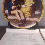 01 PRATO DE NORMAN ROCKWELL EDIÇÃO LIMITADA "A 100 DIAS DE QUEIMA DE ESTOQUE" DA SÉRIE MULHERES REDESCOBERTAS, "PONDERING ON THE PORCH"3º PRATO DA SÉRIE MULHERES REDESCOBERTAS,21,5 CM DE DIÂMETRO, BRADEX Nº 84-R70-4.3 1981 EDWIN M. KNOWLES CHINA COMPANY UM GENUÍNO CLÁSSICO ROCKWELL. FINA EDWIN M KNOWLES. COM CERTIFICADO DE AUTENTICIDADE, FEITO NOS ESTADOS UNIDOS. PERFEITO PARA FÃS DA ICÔNICA OBRA DE ROCKWELL, ESTE PRATO DE COLECIONADOR É UM ITEM ESSENCIAL PARA QUALQUER COLEÇÃO. ADICIONE ESTA PEÇA DESLUMBRANTE À SUA COLEÇÃO HOJE MESMO E ADMIRE OS DETALHES COMPLEXOS E AS BELAS CORES QUE FAZEM DESTE PRATO UMA OBRA DE ARTE. COM CERTIFICADO DE AUTENTICIDADE. ITEM COMPRADO E GARAGENS DE ANTIGUIDADES NOS EUA.SUPORTE PARA PRATO NÃO INCLUÍDO NESTA VENDA. (NO ESTADO) ATENÇÃO! FAZER A VISITAÇÃO ANTES DE ARREMATAR, NÃO SABEMOS SE FUNCIONA, LEILÃO NÃO TEM GARANTIA E NEM DEVOLUÇÃO, SUJEITO A POSSÍVEIS AVARIAS VISÍVEIS/OCULTAS E/OU AUSÊNCIA DE COMPONENTES.