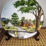 01 RARO PRATO PORCELANA FRANCISCANA DA HISTORIC PROVIDENCE MINT WORLD PREMIER FIRST EDITION, DE 1983, DA SÉRIE THE VANISHING AMERICAN BARN, DA HARRIS HIEN, A SEGUNDA EDIÇÃO DA SÉRIE, INTITULADA "THE LOG BARN", NEW "ENGLAND BARN". O PRATO APRESENTA UMA REPRESENTAÇÃO ÚNICA, DETALHADA E COLORIDA DE UM TIPO DE CELEIRO AMERICANO, SITUADO EM UM CENÁRIO DE FAZENDA DE DIFERENTES REGIÕES DO PAÍS, COM DETALHES DOURADOS NA BORDA. ESTAMPADAS NA PARTE INFERIOR COM O NOME DA SÉRIE, TÍTULO, ASSINATURA IMPRESSA DO ARTISTA E A MARCA THE HISTORIC PROVIDENCE MINT, E MEDEM APROXIMADAMENTE 21,8 CM DE DIÂMETRO. EM EXCELENTE ESTADO, POSSUI A CAIXA ORIGINAL E OS DOCUMENTOS.O SUPORTE DO PRATO NÃO ESTÁ INCLUÍDO. (NO ESTADO) ATENÇÃO! FAZER A VISITAÇÃO ANTES DE ARREMATAR, NÃO SABEMOS SE FUNCIONA, LEILÃO NÃO TEM GARANTIA E NEM DEVOLUÇÃO, SUJEITO A POSSÍVEIS AVARIAS VISÍVEIS/OCULTAS E/OU AUSÊNCIA DE COMPONENTES.