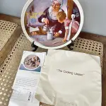 01 PRATO DE NORMAN ROCKWELL PARA O DIA DAS MÃES DE 1982, "THE COOKING LESSON", DA PORCELANA FINA KNOWLES. O NÚMERO DO PRATO É 13025N , DA PRIMEIRA EDIÇÃO LIMITADA. O SÉTIMO DE UMA SÉRIE ANUAL PARA O DIA DAS MÃES. CERTIFICADO PELA ROCKWELL SOCIETY OF AMERICA. ESTE PRATO É UMA EDIÇÃO LIMITADA, PERMANENTEMENTE FECHADA, FEITA EM 7 DE MAIO DE 1982 PELA KNOWLES, A MARCA MAIS ANTIGA DA AMÉRICA EM PORCELANA FINA. O PRATO MEDE 21,8 CM DE DIÂMETRO E ESTÁ EM ÓTIMO ESTADO ITEM COMPRADO EM 2/10/1982 COM CERTIFICADO DE AUTENTICIDADE NOTAS E DOCUMENTOS DE COMPRA.  ITEM COMPRADO EM GARAGENS DE ANTIGUIDADES NOS EUA.SUPORTE PARA PRATO NÃO INCLUÍDO NESTA VENDA. (NO ESTADO) ATENÇÃO! FAZER A VISITAÇÃO ANTES DE ARREMATAR, NÃO SABEMOS SE FUNCIONA, LEILÃO NÃO TEM GARANTIA E NEM DEVOLUÇÃO, SUJEITO A POSSÍVEIS AVARIAS VISÍVEIS/OCULTAS E/OU AUSÊNCIA DE COMPONENTES.