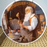 01 PRATO DE NORMAN ROCKWELL EDIÇÃO DA SAFRA 1984 PORCELANA FINA ESTA É PARTE DA PLACA DE EDIÇÃO LIMITADA DA THE ROCKWELL SOCIETY OF AMERICA Nº DA ÚNICA EDIÇÃO NOMEADA PAPAI NOEL EM SUA OFICINA POR NORMAN ROCKWELL É A DÉCIMA PRIMEIRA EDIÇÃO DE UMA SÉRIE ANUAL DE PLACAS EDIÇÃO PERMANENTEMENTE FECHADA VISUAL MURAL PINTADO EM 1922 POR NORMAN ROCKWELL FEITO POR EDWIN M KNOWLES NOME MAIS ANTIGO DA AMÉRICA EM PORCELANA FINA NÚMERO BRADEX 84-R70-1.11 PRATO DE NUMERO 17170 C CERTIFICADO DE AUTENTICAÇÃO OFICIALMENTE CARIMBADO CARIMBADO E ASSINADO, QUE É COMO SEU TÍTULO NA PARTE DE TRÁS,  COM CAIXA ORIGINAL COM PARTE DA ETIQUETA DO SELO THE BRADFORD EXCHANGE COM UM PANFLETO DA HISTÓRIA DESTA PLACA. MEDE 8 1/4 DE DIÂMETRO SEM ARRANHÕES SEM LASCAS SEM RACHADURAS  ITEM DE COLECIONADOR. ITEM COMPRADO E GARAGENS DE ANTIGUIDADES NOS EUA. SUPORTE PARA PRATO NÃO INCLUÍDO NESTA VENDA. (NO ESTADO) ATENÇÃO! FAZER A VISITAÇÃO ANTES DE ARREMATAR, NÃO SABEMOS SE FUNCIONA, LEILÃO NÃO TEM GARANTIA E NEM DEVOLUÇÃO, SUJEITO A POSSÍVEIS AVARIAS VISÍVEIS/OCULTAS E/OU AUSÊNCIA DE COMPONENTES.